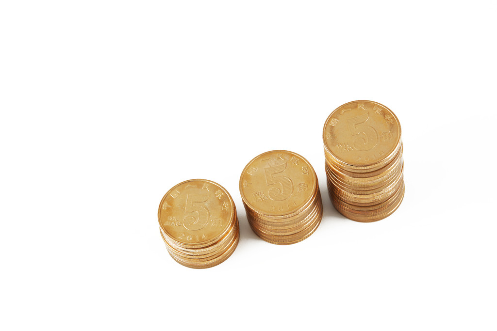 硬币堆放在桌上背景图片