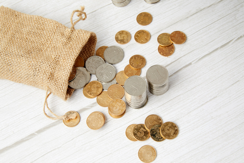 硬币堆放在桌上背景图片