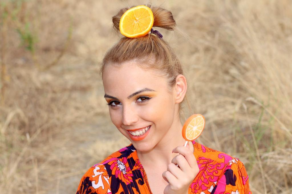 夏天户外拍照旅游头顶橙子美女模特背景图片