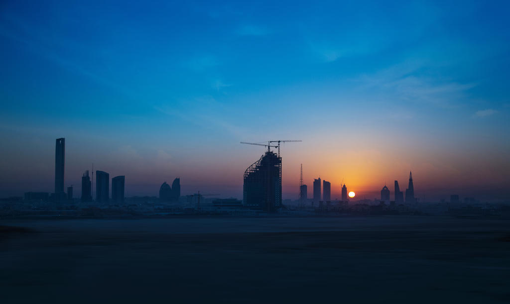 城市剪影蓝色建筑唯美天空日落下的蓝天城市景观背景图片