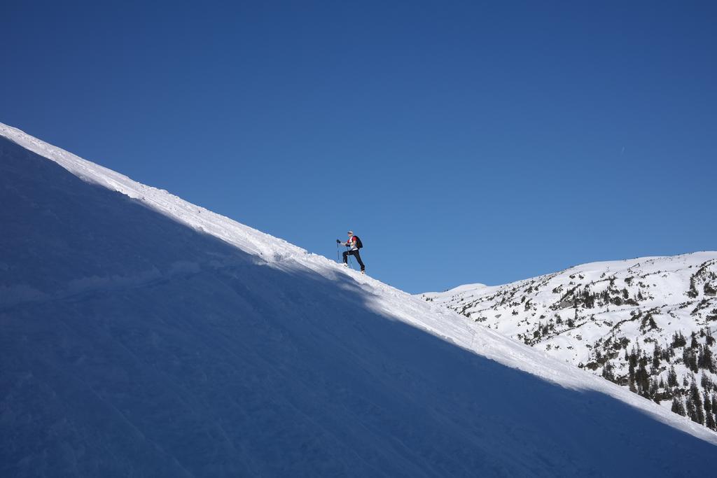 蓝白运动热血蓝天下的雪山上的登山者运动登山野外雪山背景图片