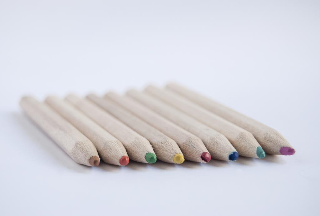 白色艺术广告极简风白色桌面上彩色铅笔背景图片