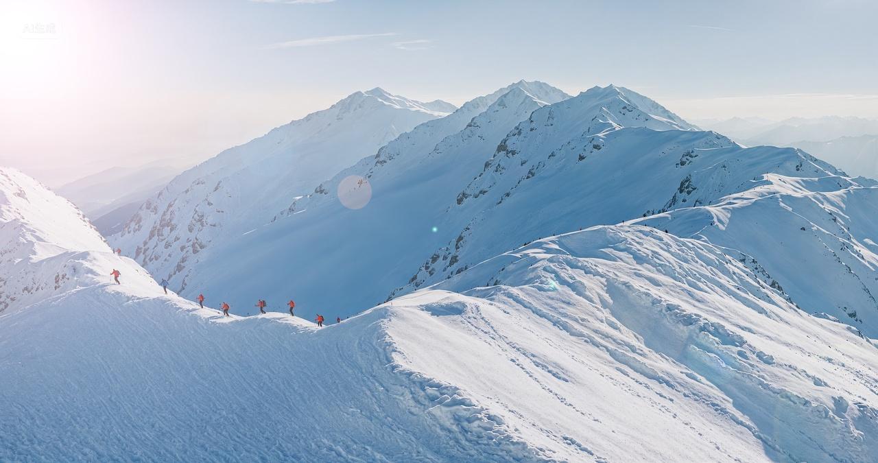 阳光下雪山山脊登山队攀登企业精神挑战
