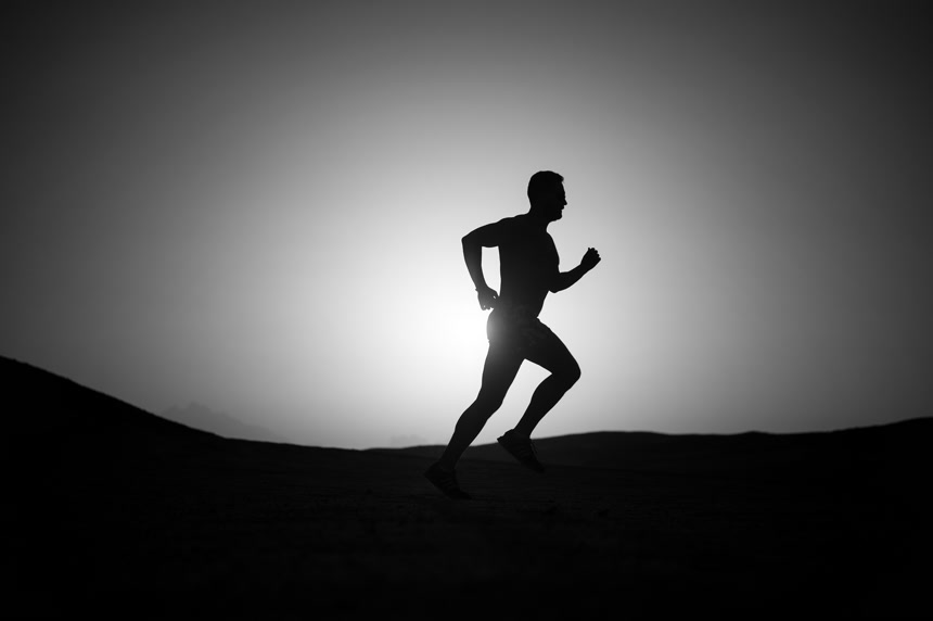 在落日的天空跑步男人的剪影   健康生活主题