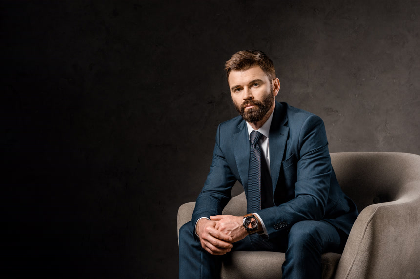 外国精英男子坐在沙发上人像半身照背景壁纸