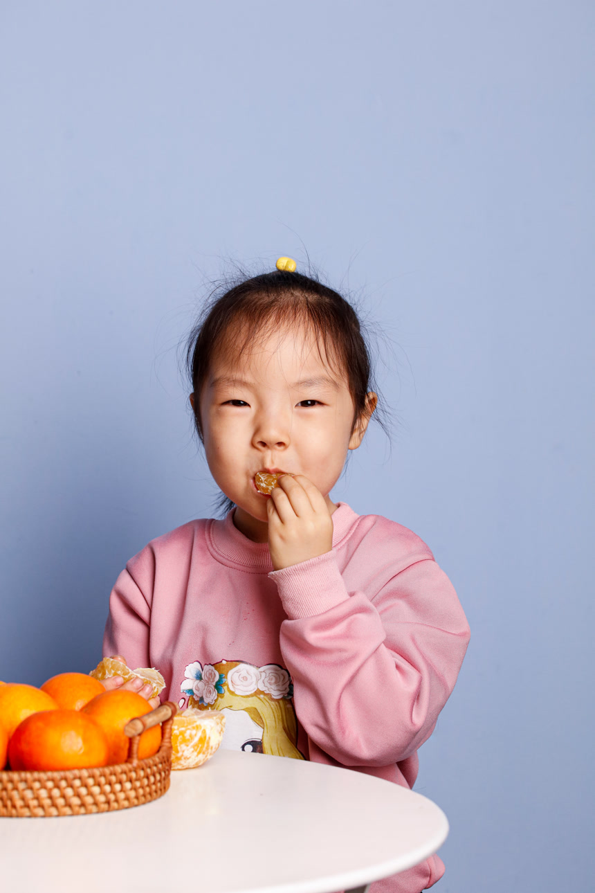 小孩正在吃着蜜桔