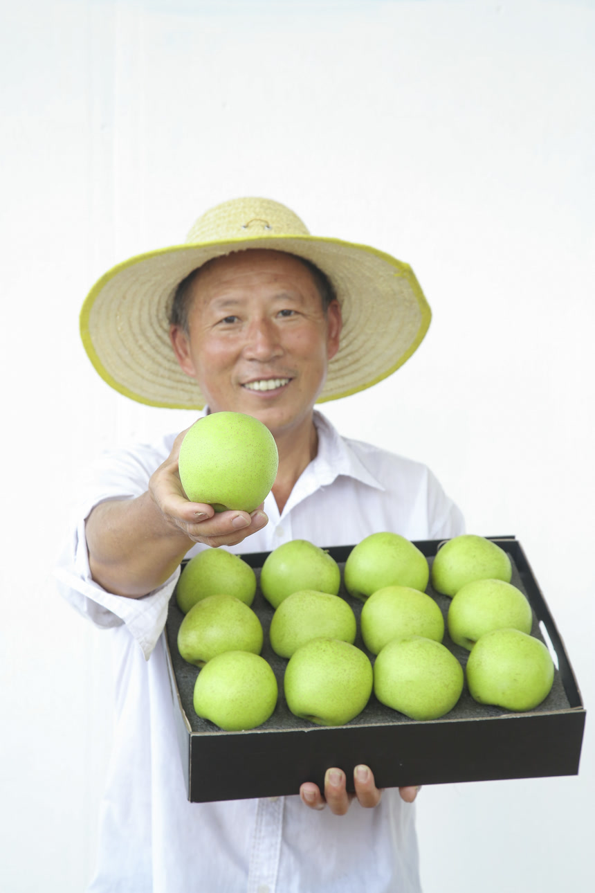 手里拿着一盒青皇冠梨