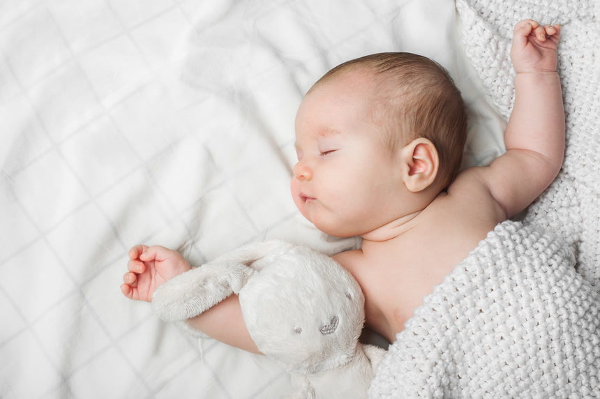 Sleeping newborn boy 2 months old with toy on white background close up and copy space睡觉宝宝健康生活方式.