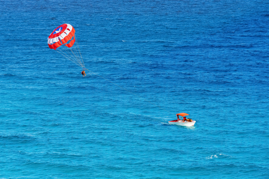 在加勒比海热带海洋度假概念墨西哥坎昆拖在船后的滑翔伞度假休闲娱乐