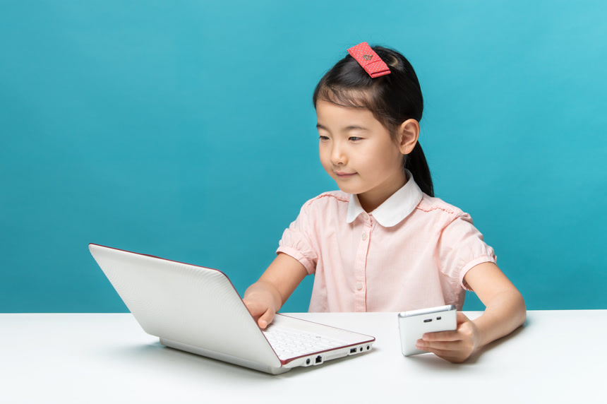 亚洲小女孩使用笔记本电脑和手机学习小学教育
