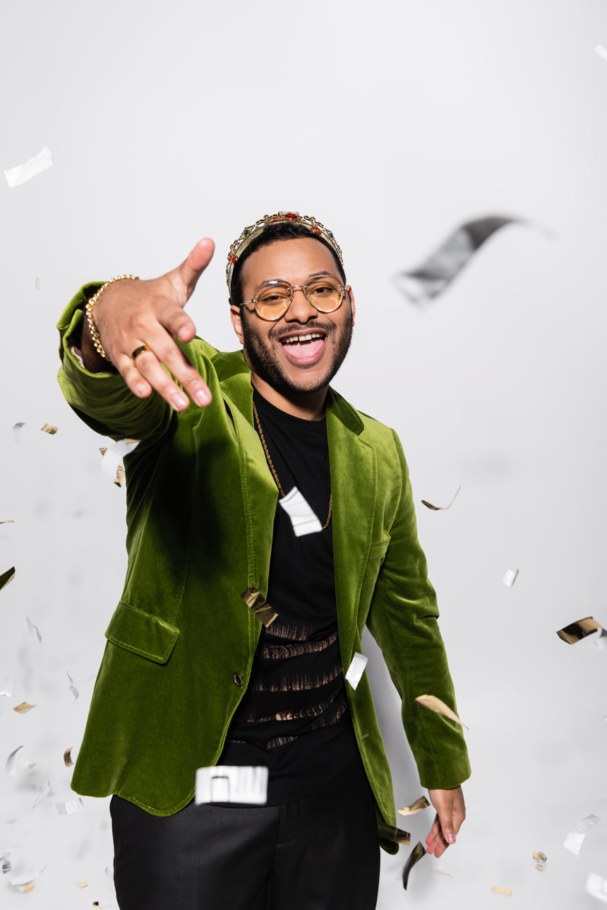 兴奋的印度嘻哈歌手身穿绿色天鹅绒外套对着做手势生活方式