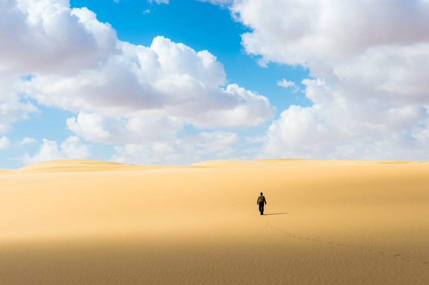 一个男人在沙漠里行走旅游景区宣传