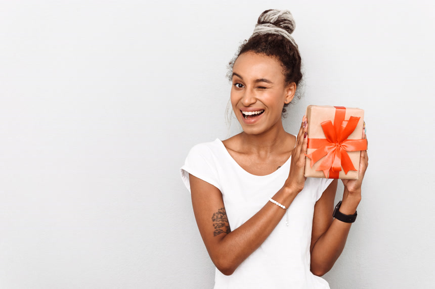 一个快乐的年轻非洲女人手里拿着礼物盒的照片肖像