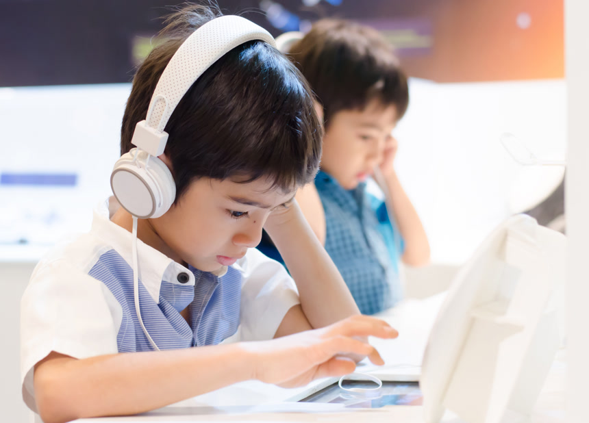 在教室里的带着耳机的小男孩生活方式