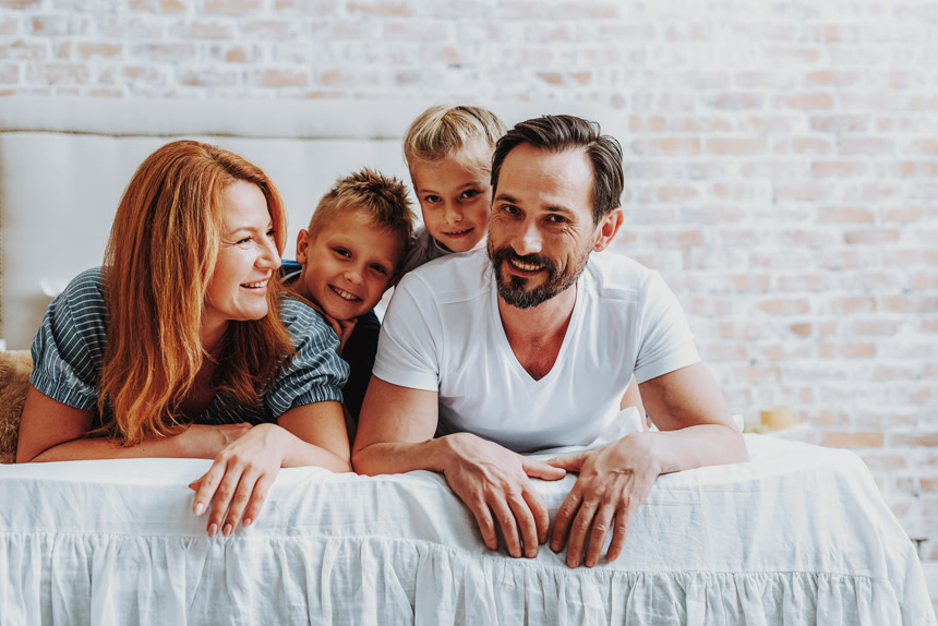 家庭概念 一家四口躺在床上开心的笑着