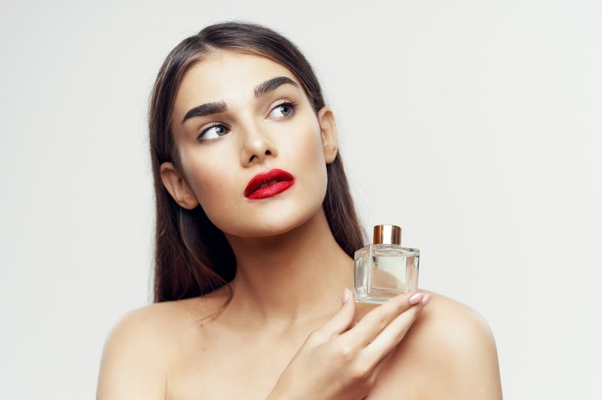 年轻美丽女子的画像带有白色背景的香水瓶美容肖像