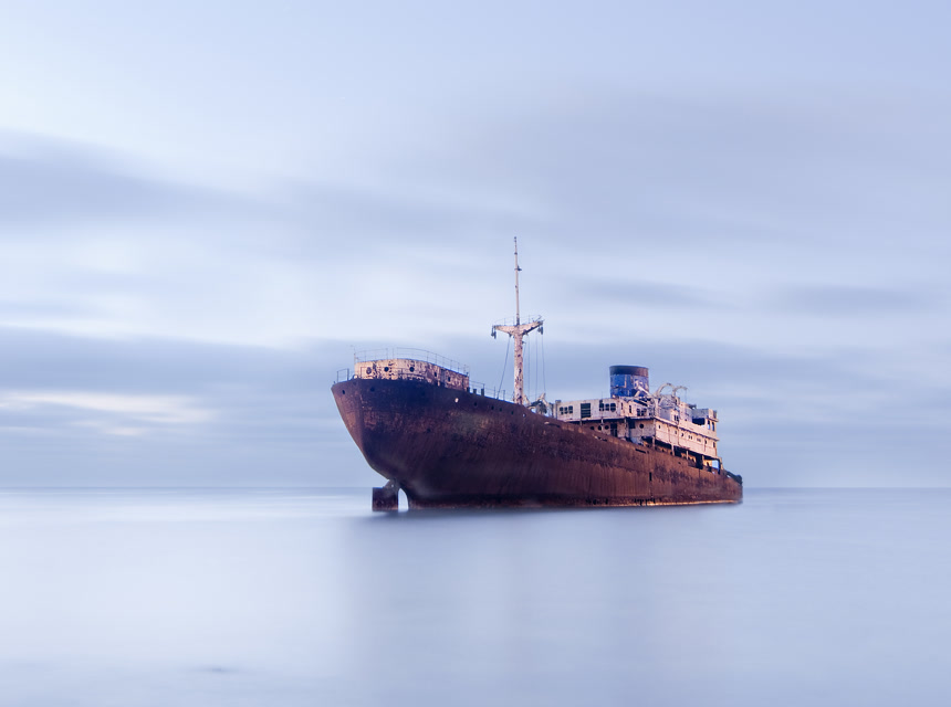 摄影风格多云天气下海面上行驶的老轮船摄影图