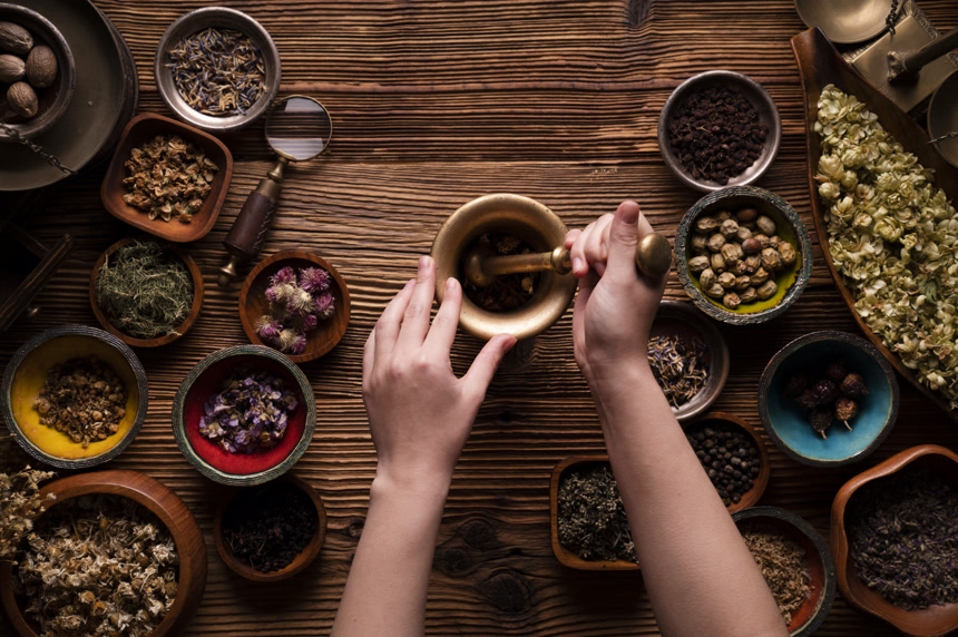 自然科学背景。草本成分的配制.粗木桌上的碗和黄铜砂浆中的干草分类.