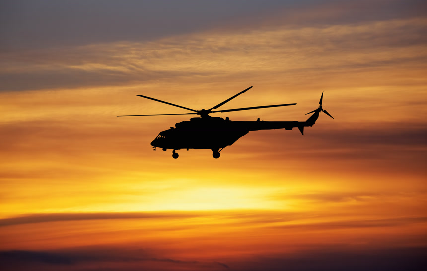 在黄昏里飞行的直升机航空机器自然景观