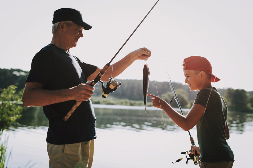 爷爷带着孙子在湖边钓鱼  收获一条鱼的喜悦    户外活动