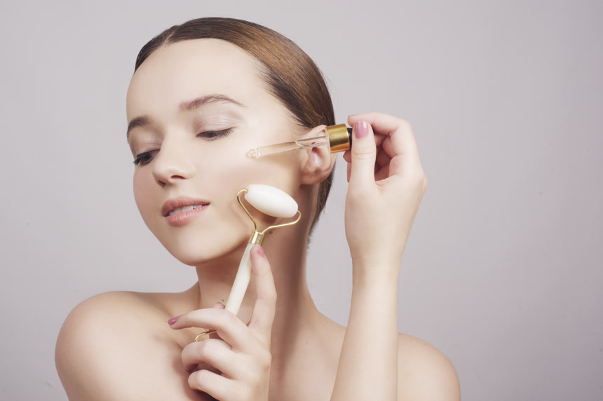 一个漂亮的黑发女士在她的脸上涂上化妆品美容疗法