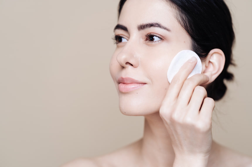 年轻的黑发女人使用棉片擦拭皮肤美容美业