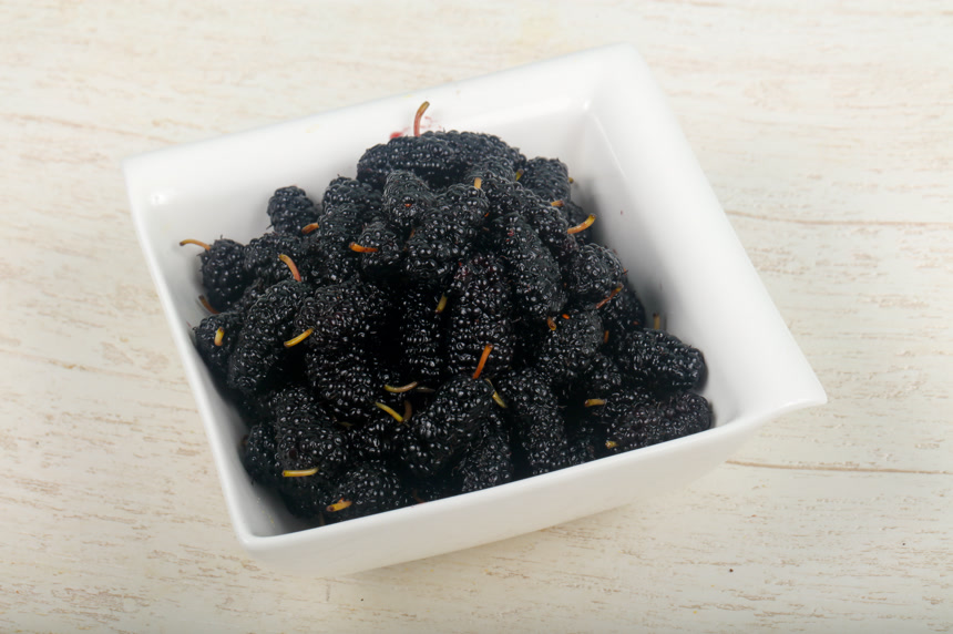 木背景上的黑紫色桑葚健康生活方式