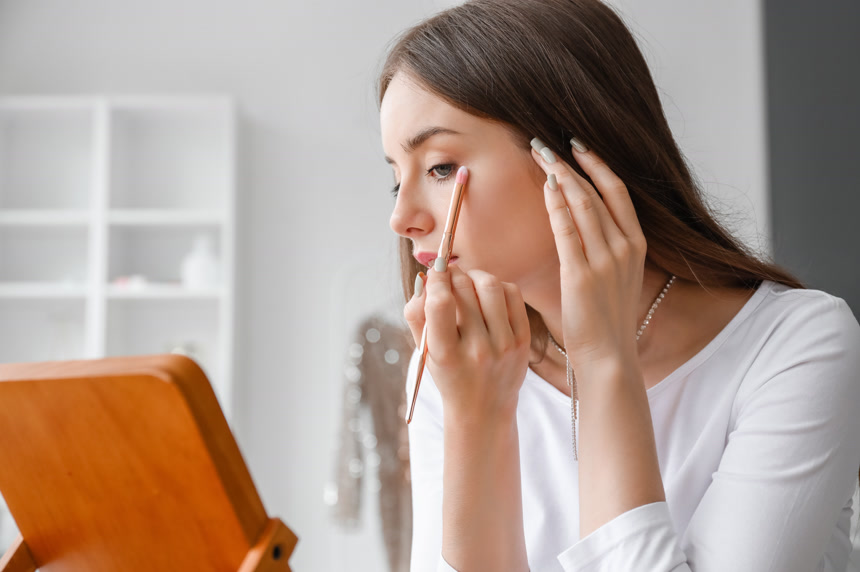 漂亮的年轻女人对着镜子化妆特写生活方式