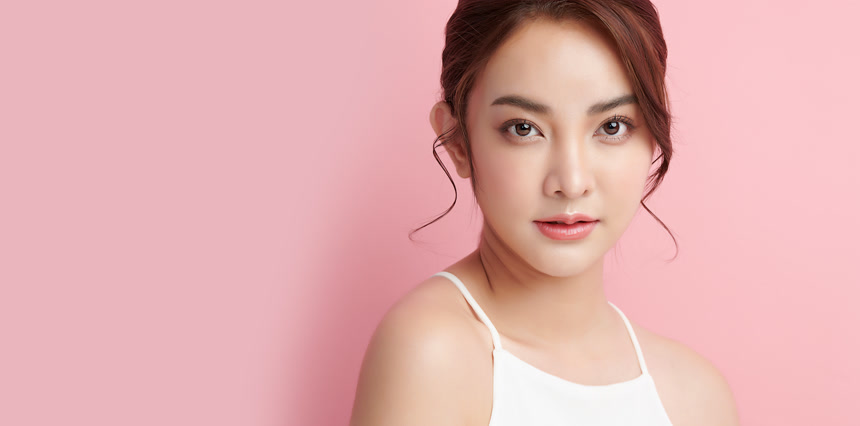 年轻美丽的亚洲女人，皮肤清澈，粉红背景，面部护理，面部护理，美容，美容美发，水疗，亚洲女性肖像.