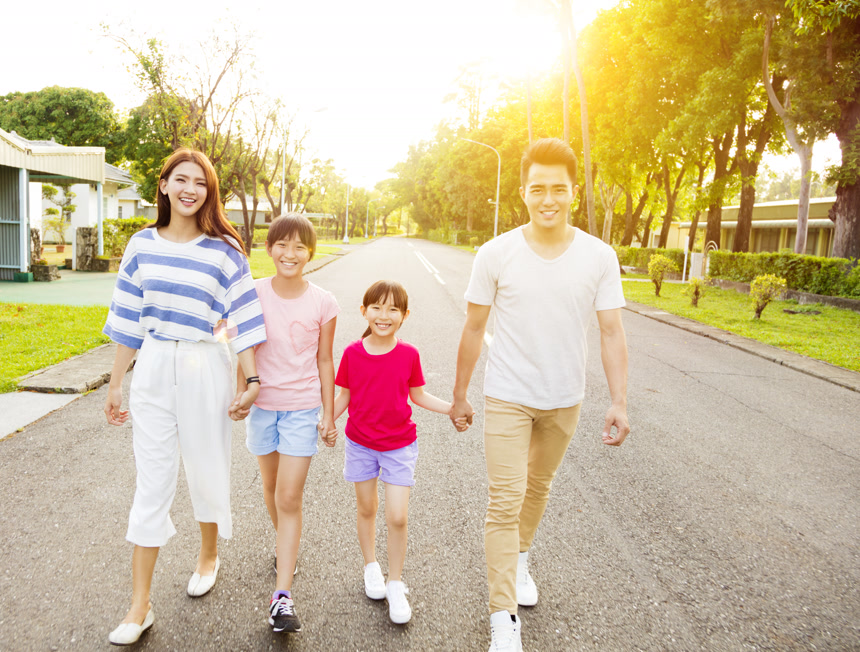 逆光拍摄幸福的一家四口手拉手散步