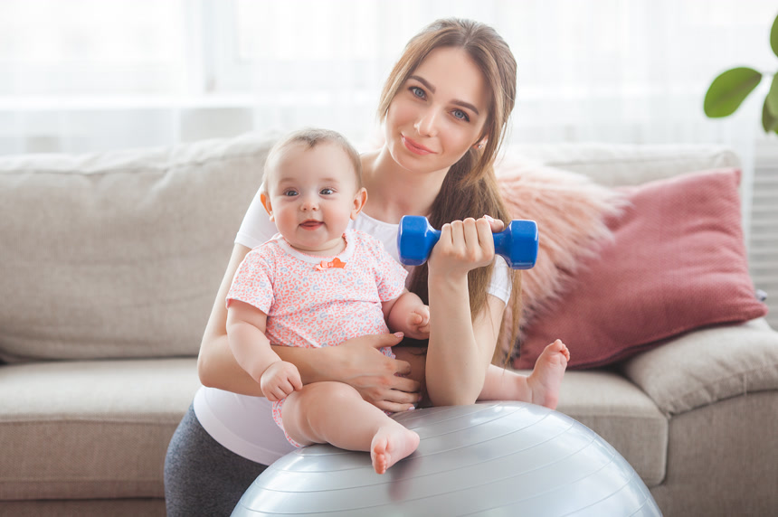 年轻漂亮的母亲在家里和她的小孩玩耍健身生活方式母婴