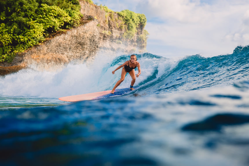 冲浪板上的女人在海洋中冲浪  极限运动旅游概念