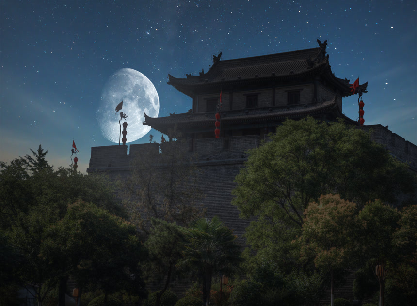 西安市夜里城墙巨大的月亮布满星星的夜空挂着红灯笼高大的绿树