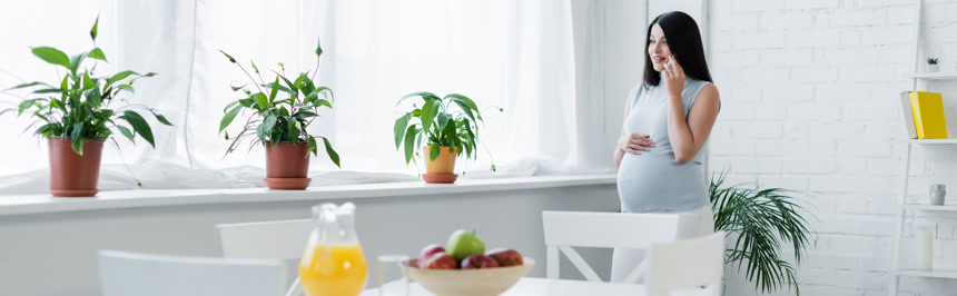 年轻孕妇在餐桌前打电话生活方式