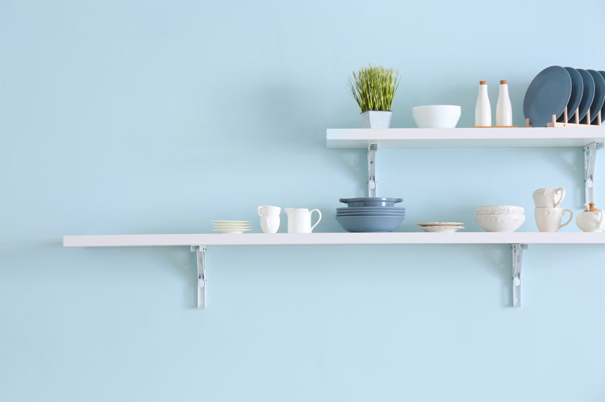 蓝色墙上挂有板子上装着盘子餐具杯子绿植生活场景厨房图片