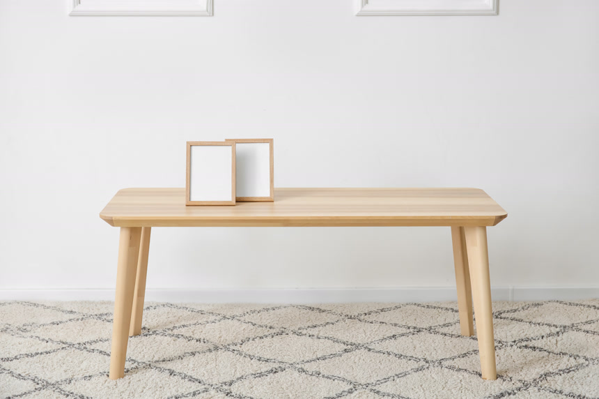 地毯上的木桌子上放着两个空白的相框生活场景