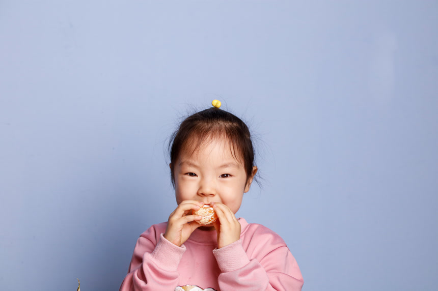 小孩正在吃着蜜桔