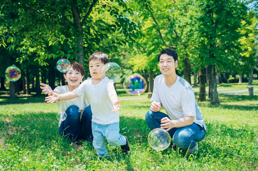 父母和他们的孩子在公园玩肥皂泡生活方式