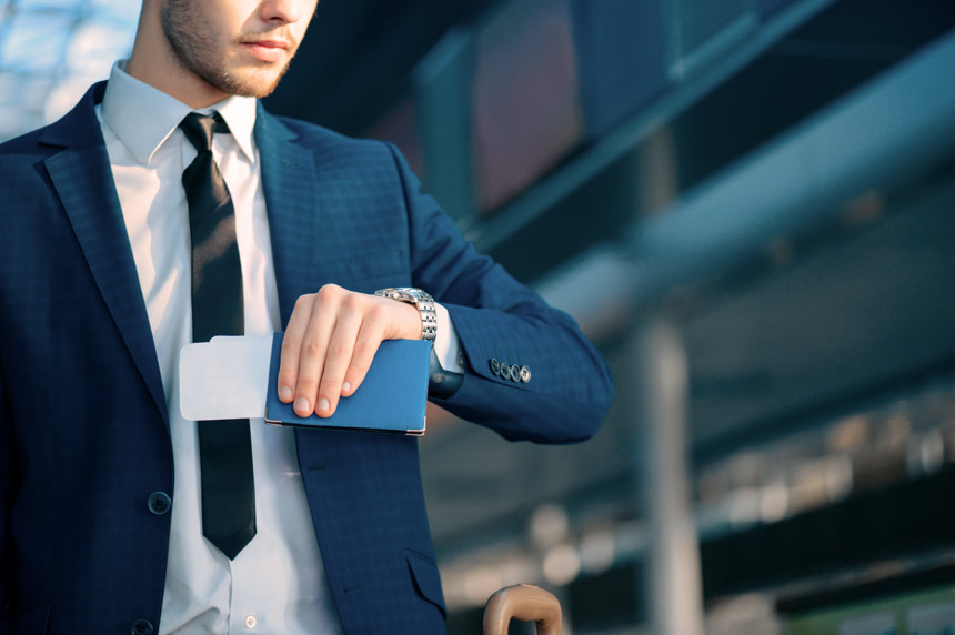 商务正装男人看手表手拿签证机票赶时间