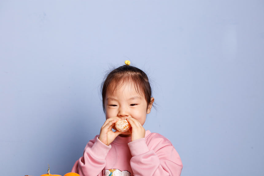 小孩正在吃着蜜桔