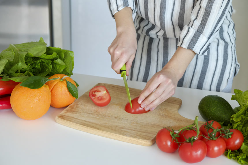 在厨房里，一个女人在切各种水果、蔬菜 健康生活方式