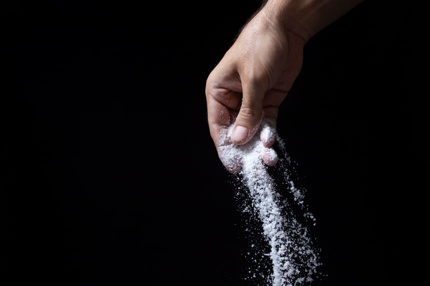 用手撒盐黑色背景图调味料美食健康生活方式