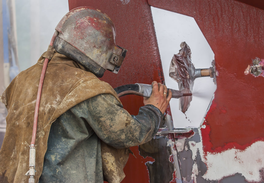 用高压喷砂工具喷砂被腐蚀的帆船船体的工人生活方式