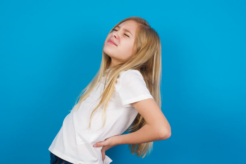 美丽的白人女孩捂着后背表情痛苦摄影棚拍摄