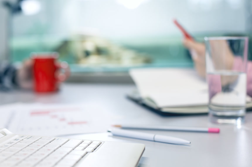 商务办公室桌子上的圆珠笔和笔记本电脑