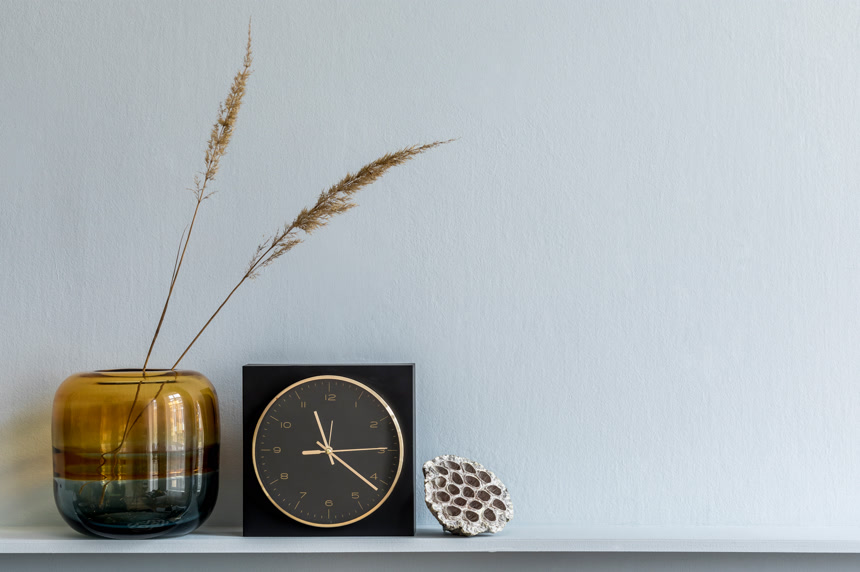 木制架子上简约的构图设计黑色钟表花瓶里有干花居家生活方式