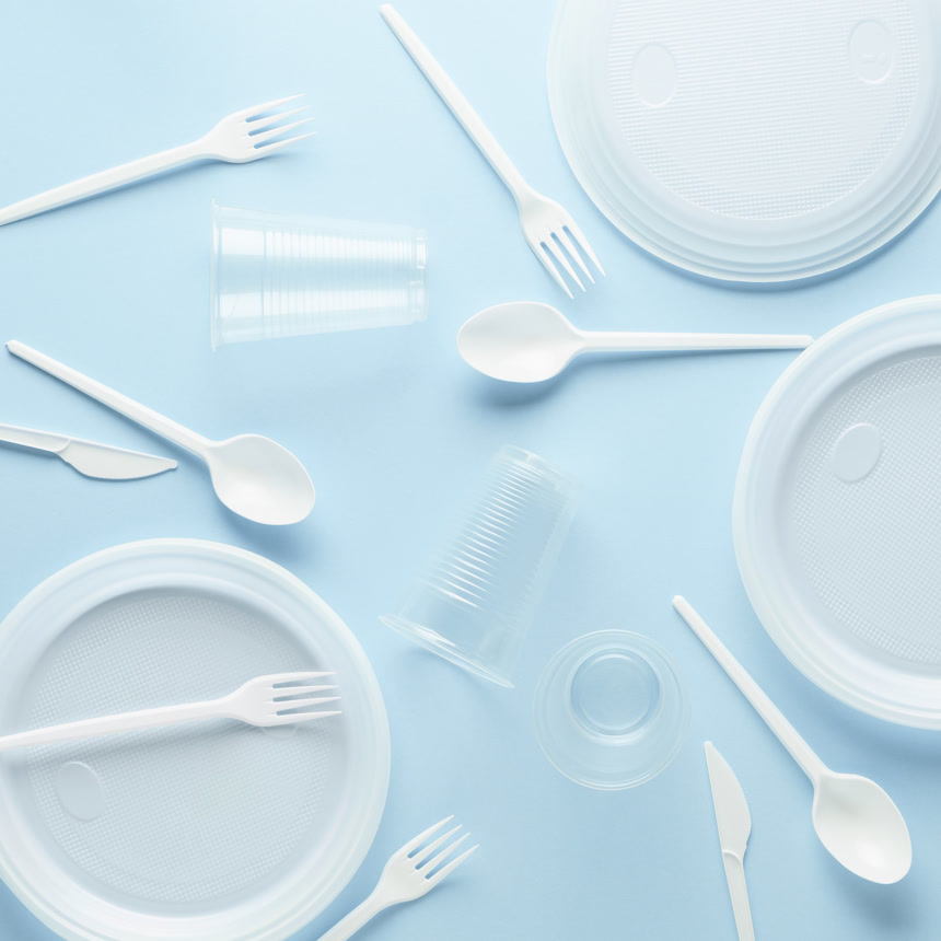 蓝色背景上的各种白色塑料一次性餐具休闲生活