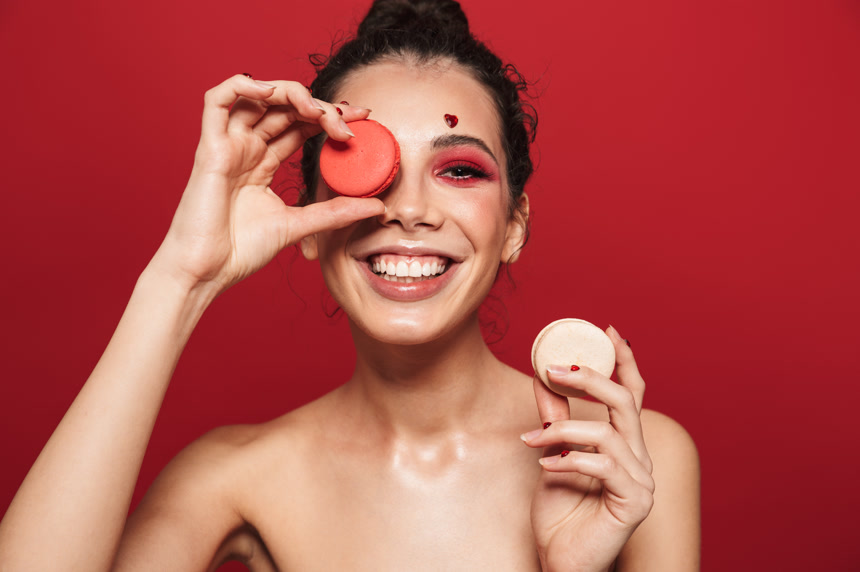 女模特拿着马卡龙摆动作彩妆棚拍摄影