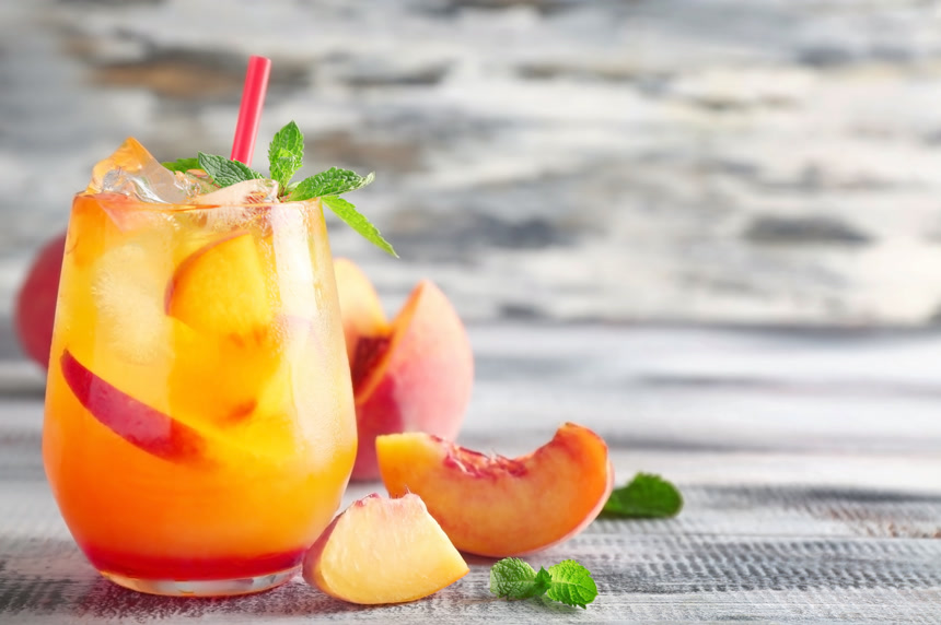 玻璃杯里的新鲜鸡尾酒及杯子旁边的桃子   饮品店广告宣传