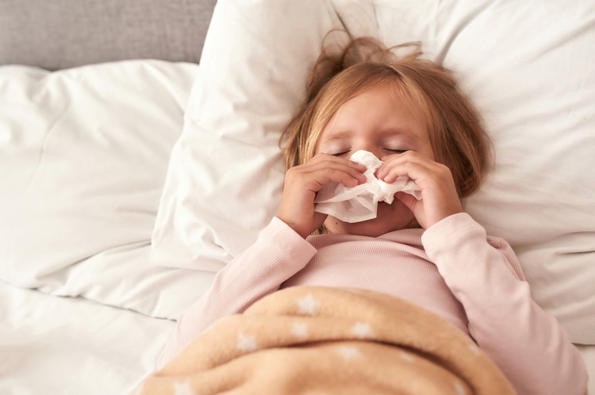 一张年轻姑娘在床上打喷嚏的照片健康生活方式